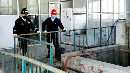 图为鹤矿峻德煤矿在检查缓浆池清静运行情形_副本